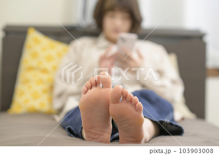 ベッドでスマホを見る若い女性 ベッドでスマホを見る若い女性 103903008