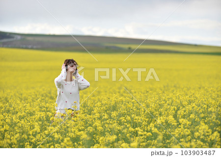 Caucasian girl listening to music with headphone in the outdoors Caucasian girl listening to music with headphone in the outdoors 103903487