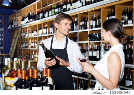 Seller in a wine house and visitor 103906946