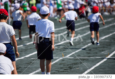 小学校の運動会で短距離走をしている学生達の後ろ姿 103907372