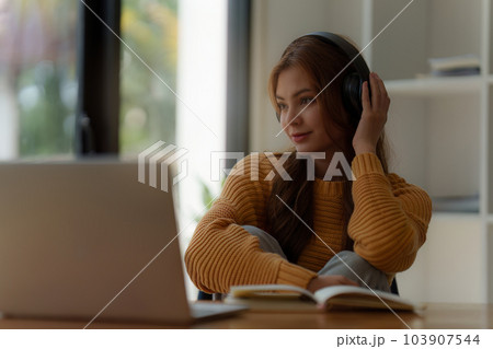 Young relaxed smiling pretty woman relaxing sitting on sofa at home. Female feeling joy enjoying with music on cozy couch Young relaxed smiling pretty woman relaxing sitting on sofa at home. Female feeling joy enjoying with music on cozy couch 103907544