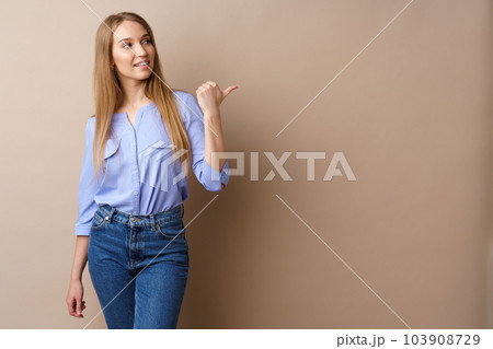 Pretty nice young woman pointing to copy space for advertising Pretty nice young woman pointing to copy space for advertising 103908729
