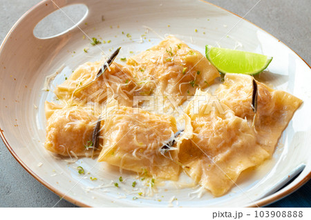 Italian dish ravioli with parmesan in a plate 103908888