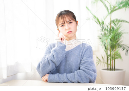 部屋で考え事をしている若い女性 部屋で考え事をしている若い女性 103909157