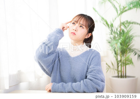 部屋で考え事をしている若い女性 103909159