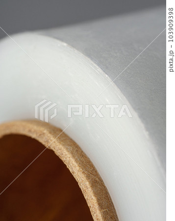 Roll of transparent polyethylene cling film on gray background 103909398