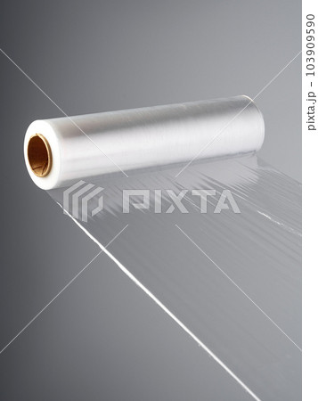 Roll of transparent polyethylene cling film on gray background Roll of transparent polyethylene cling film on gray background 103909590