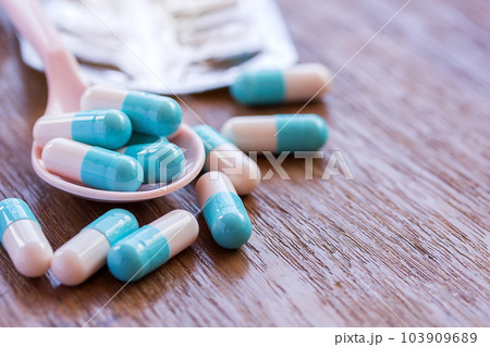Selective focus on pill spread on wooden background. 103909689