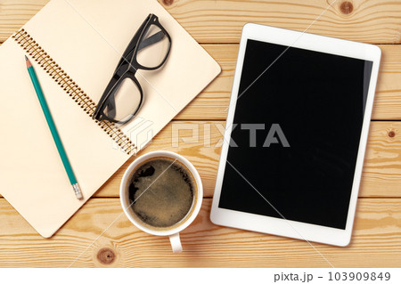 Top view of wooden table with white digital tablet with black screen on it 103909849