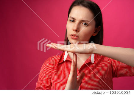 Young attractive woman showing a rejection gesture on a pink background Young attractive woman showing a rejection gesture on a pink background 103910054