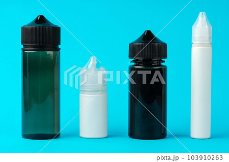 Electronic cigarettes liquid bottles on blue background Electronic cigarettes liquid bottles on blue background 103910263