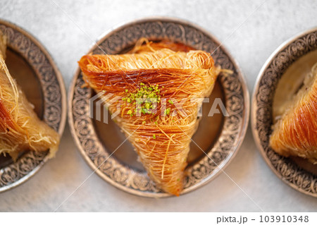 Turkish baklava on oriental metal plate on white table 103910348