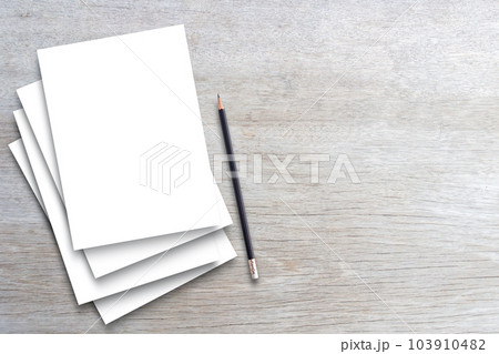 Many white paper and black pencil on wooden table background. 103910482