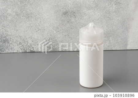 Refill liquid for electronic cigarettes on gray background Refill liquid for electronic cigarettes on gray background 103910896