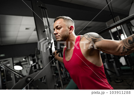 Portrait of man bodybuilder in red shirt in gym Portrait of man bodybuilder in red shirt in gym 103911288