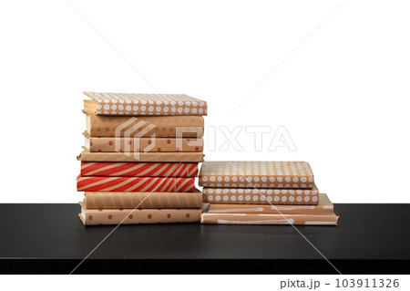 Stack of books on wooden table against white background 103911326