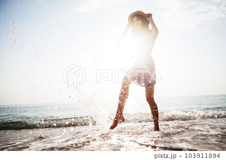 Portrait of young woman walking on the beach on sunrise Portrait of young woman walking on the beach on sunrise 103911894