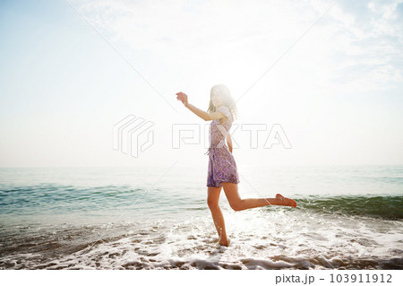 Portrait of young woman walking on the beach on sunrise Portrait of young woman walking on the beach on sunrise 103911912