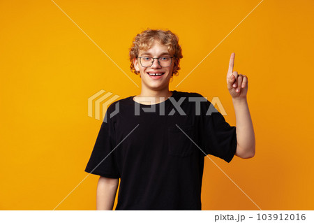 Young caucasian handsome man on yellow background thinking an idea and pointing finger up 103912016