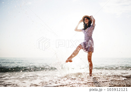 Portrait of young woman walking on the beach on sunrise 103912121