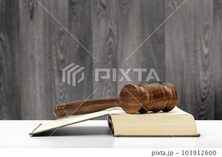 Wooden gavel and books on wooden table 103912600