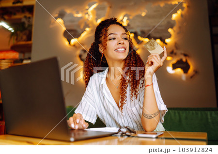 Young woman sitting at cafe making online shopping, using credit card and laptop. Online shopping Young woman sitting at cafe making online shopping, using credit card and laptop. Online shopping 103912824
