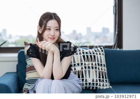 ソファに座って同僚の話を聞く女性 ソファに座って同僚の話を聞く女性 103912971
