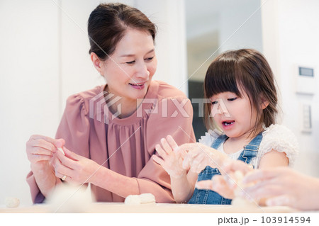 孫と一緒にお菓子作りをするおばあちゃん 孫と一緒にお菓子作りをするおばあちゃん 103914594