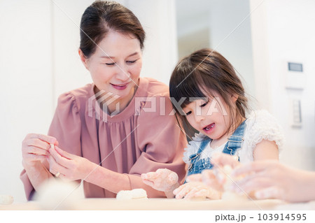 孫と一緒にお菓子作りをするおばあちゃん 孫と一緒にお菓子作りをするおばあちゃん 103914595