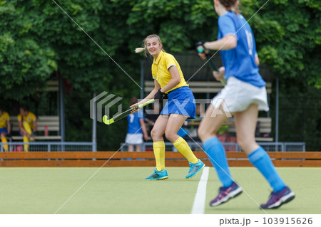 Young woman on the pitch playing field hockey game Young woman on the pitch playing field hockey game 103915626