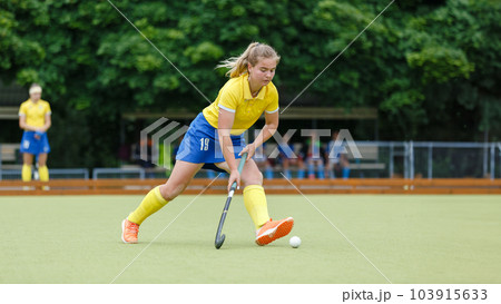 Field hockey female player leading the ball in attack Field hockey female player leading the ball in attack 103915633
