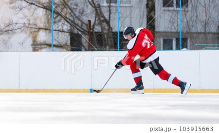 Hockey player with puck on the rink. Image with copyspace Hockey player with puck on the rink. Image with copyspace 103915663