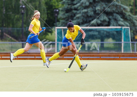Field hockey female player leading the ball in attack Field hockey female player leading the ball in attack 103915675