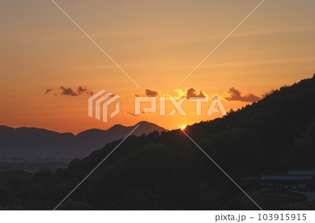 夕暮れ時の風景、山の向こうに沈む太陽、黄昏の輝き。一日の終わり 103915915