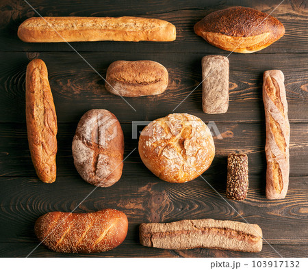 Various fresh loaves of bread on wooden background Various fresh loaves of bread on wooden background 103917132