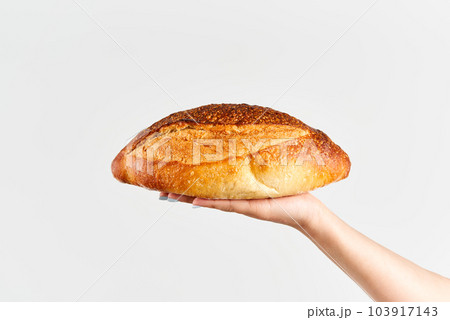 Homemade multigrain bread in woman hand over white background Homemade multigrain bread in woman hand over white background 103917143