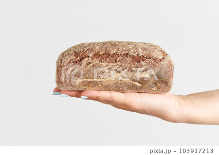 Homemade multigrain bread in woman hand over white background 103917213