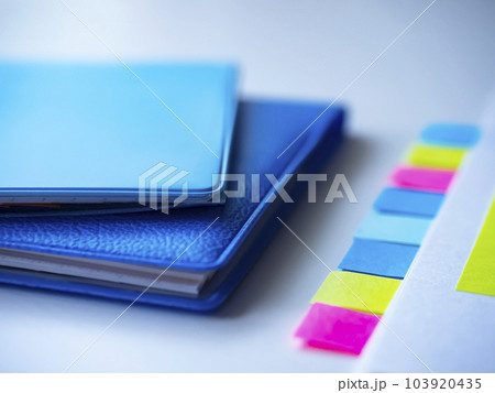 テーブルに置かれた手帳と付箋の付いた書類 103920435