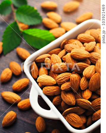 Peeled almonds. Almond kernels lie in a white plate. Top view with copy space. Advertising photo for Peeled almonds. Almond kernels lie in a white plate. Top view with copy space. Advertising photo for 103921469