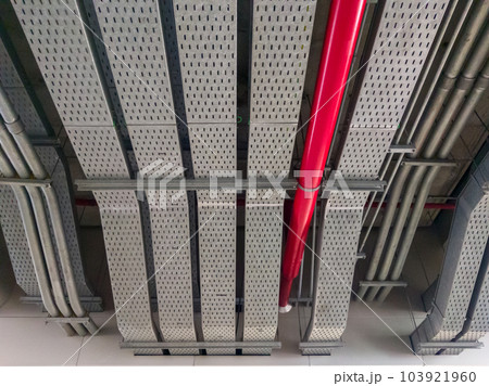 The large red pipe of the fire protection system is hanging on the ceiling. The large red pipe of the fire protection system is hanging on the ceiling. 103921960