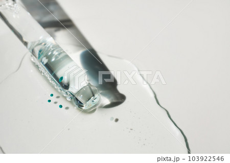 Pipette and drop of cosmetic product with blue particles, selective focus 103922546