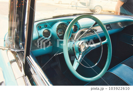 Front seat and steering wheel of a classic car viewed from outside the window looking in Front seat and steering wheel of a classic car viewed from outside the window looking in 103922610