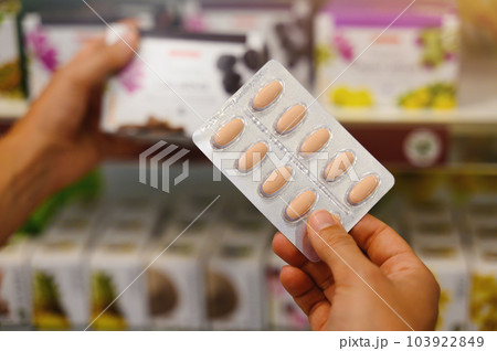 Pharmacist woman shows pills in blisters at the pharmacies 103922849