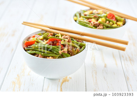 Fried pork with green beans ginger hot peppers and spices on a wooden table. Asian cuisine. 103923393