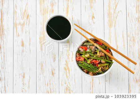 Traditional Chinese food, Szechuan style pork with green bean, ginger and red peppers on a white wooden table. 103923395