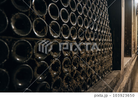 Wine bottles stacked in a bodega 103923650