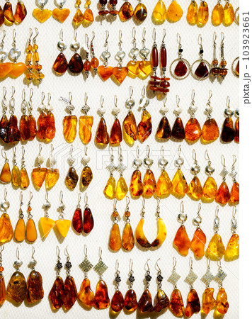 Light background with lots of yellow, golden, honey and brown natural amber earrings in silver 103923661