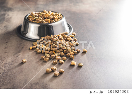 Dry kibble pet food. Dog or cat food on old table. Dry kibble pet food. Dog or cat food on old table. 103924308