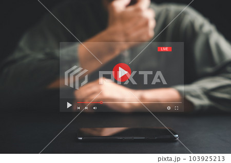 Man initiates live streaming on a smartphone, captivated by the video streaming and multimedia displayed on the screen. Embrace the fusion of technology and lifestyle in the realm of social media. 103925213