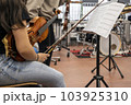 Real life young music students during rehearsals. Musical instruments and music stand with stave. 103925310